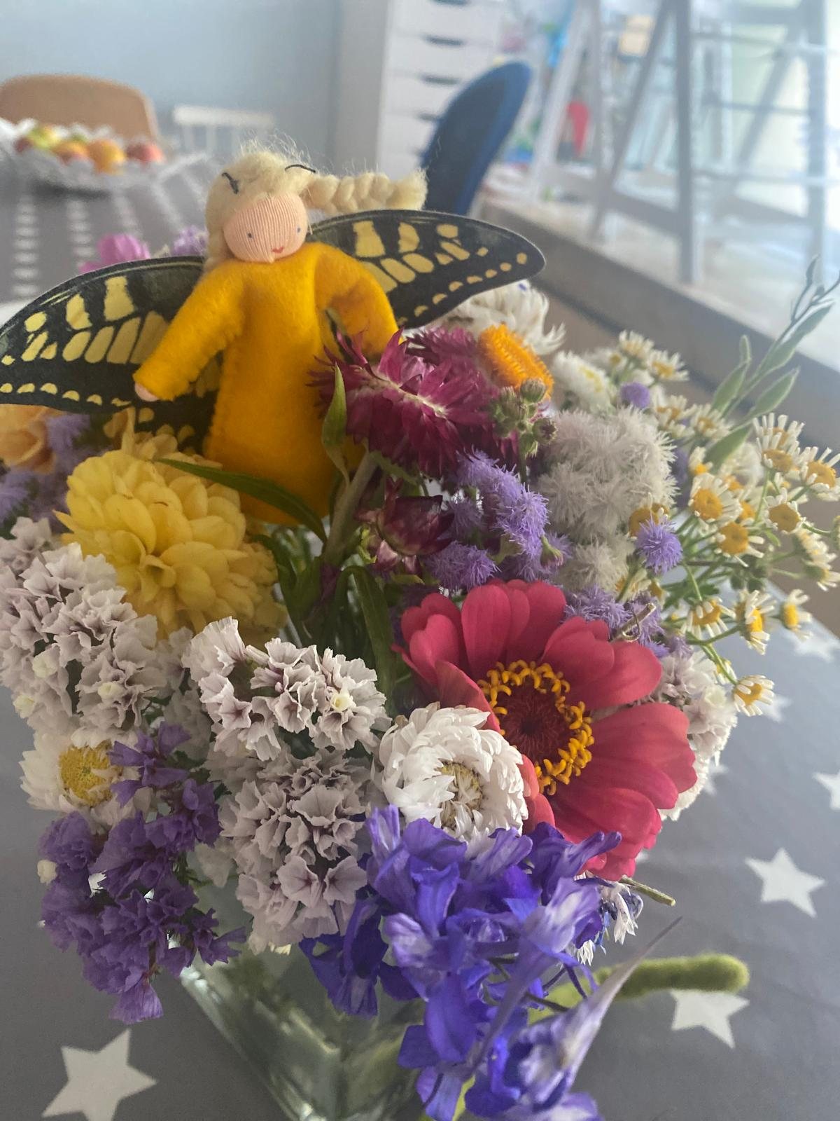 Bunter Wiesenblumenstrauß mit einer Blütenfee mit Schmetterlingsflügeln